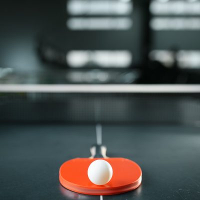 Table tennis racket with ball at the net closeup